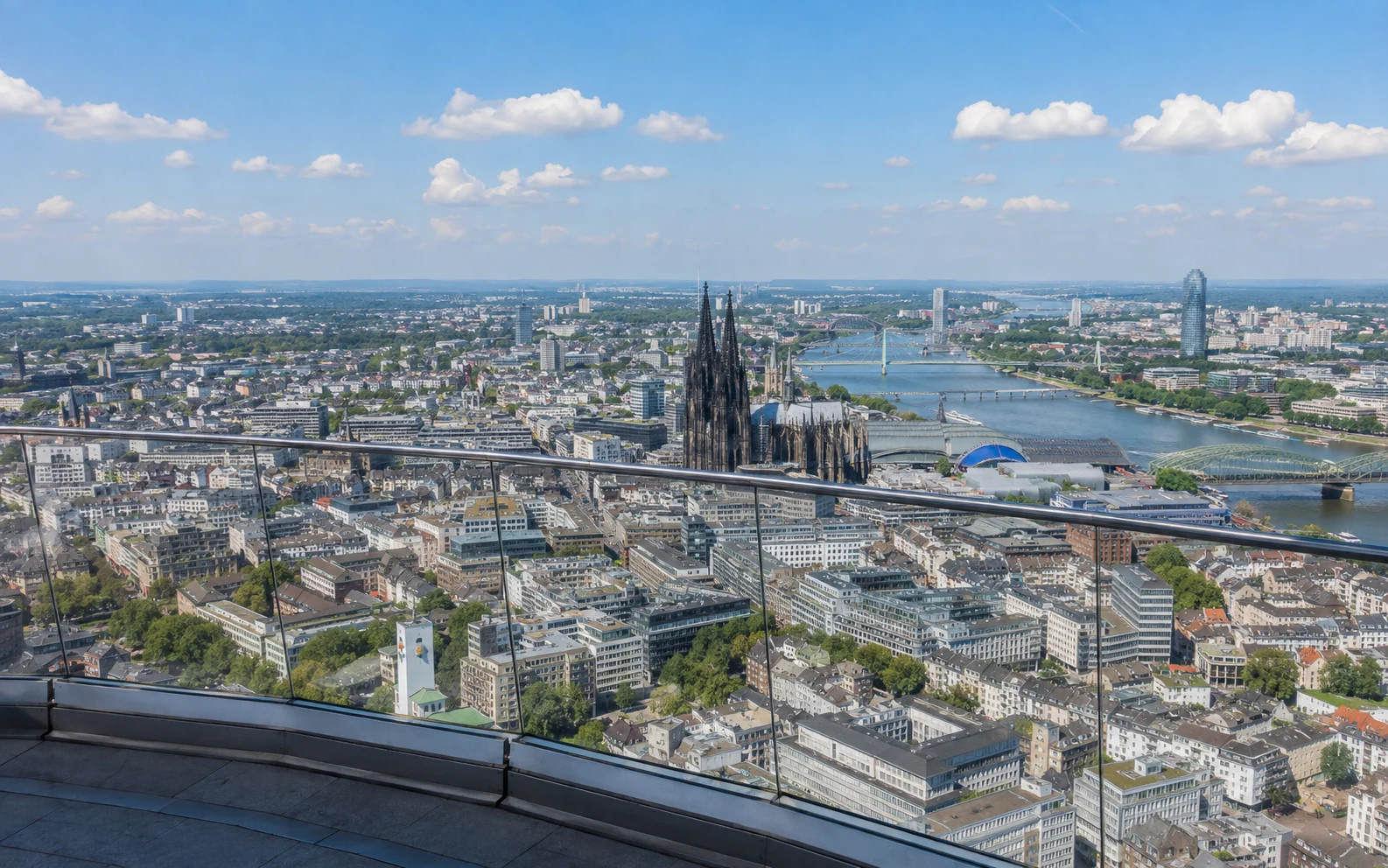 Blick von einem Aussichtspunkt über Köln mit Rhein und Dom in der Ferne